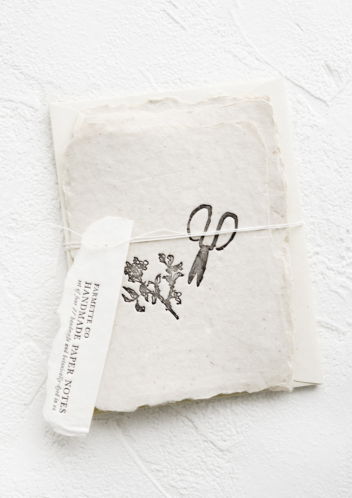 A packaged set of cards made from handmade paper with a letterpress printed image of garden shears.
