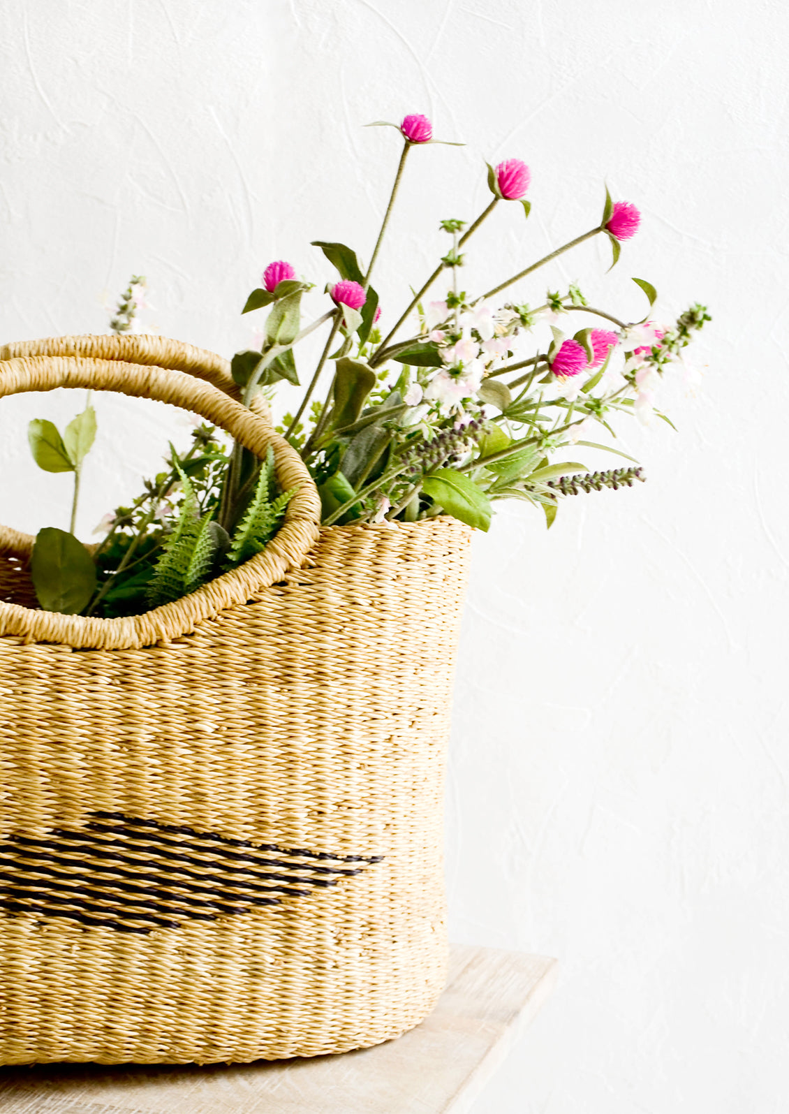 Assorted faux wildflowers in woven shopper
