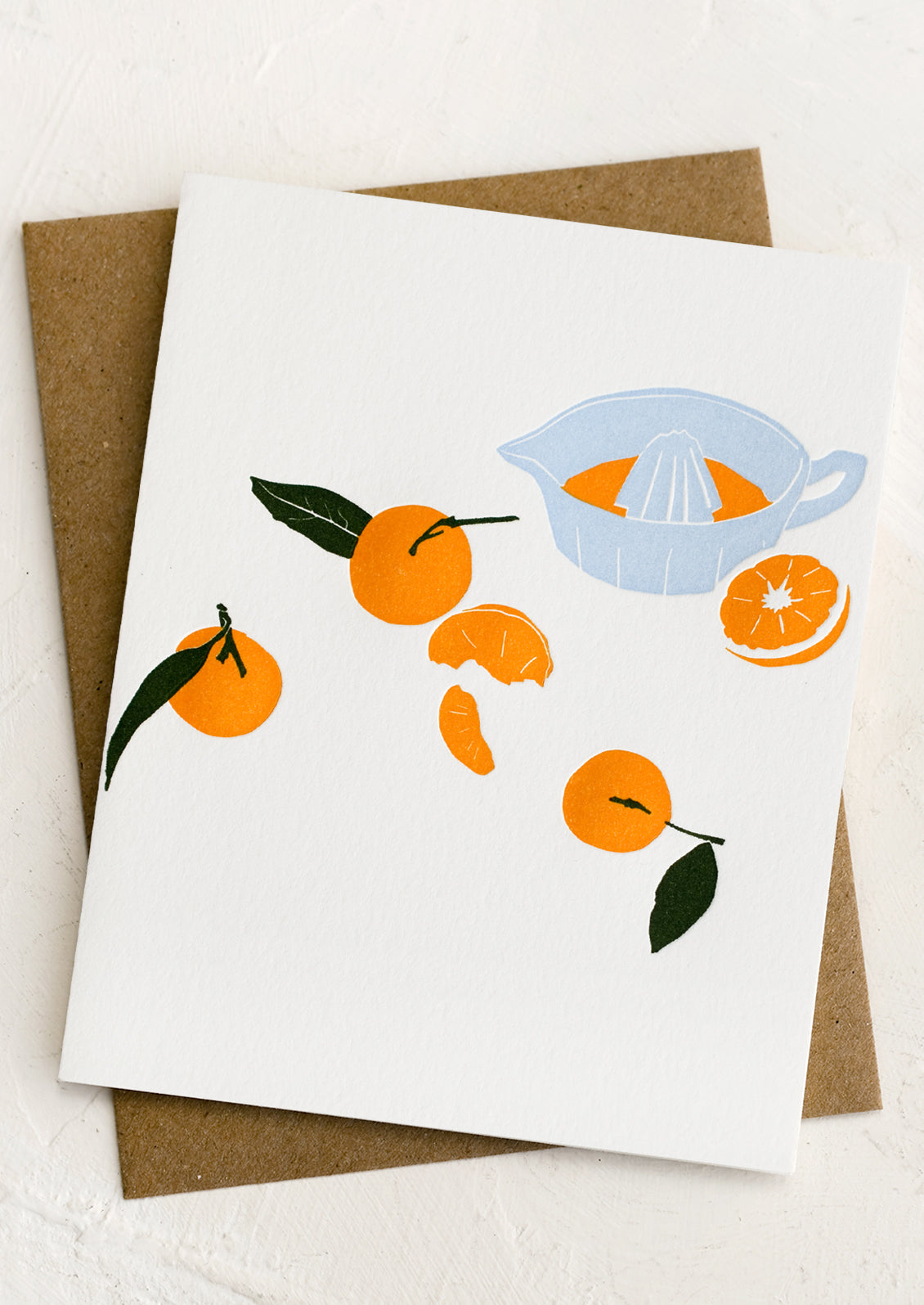 A letterpress greeting cards with image of oranges and juicer.