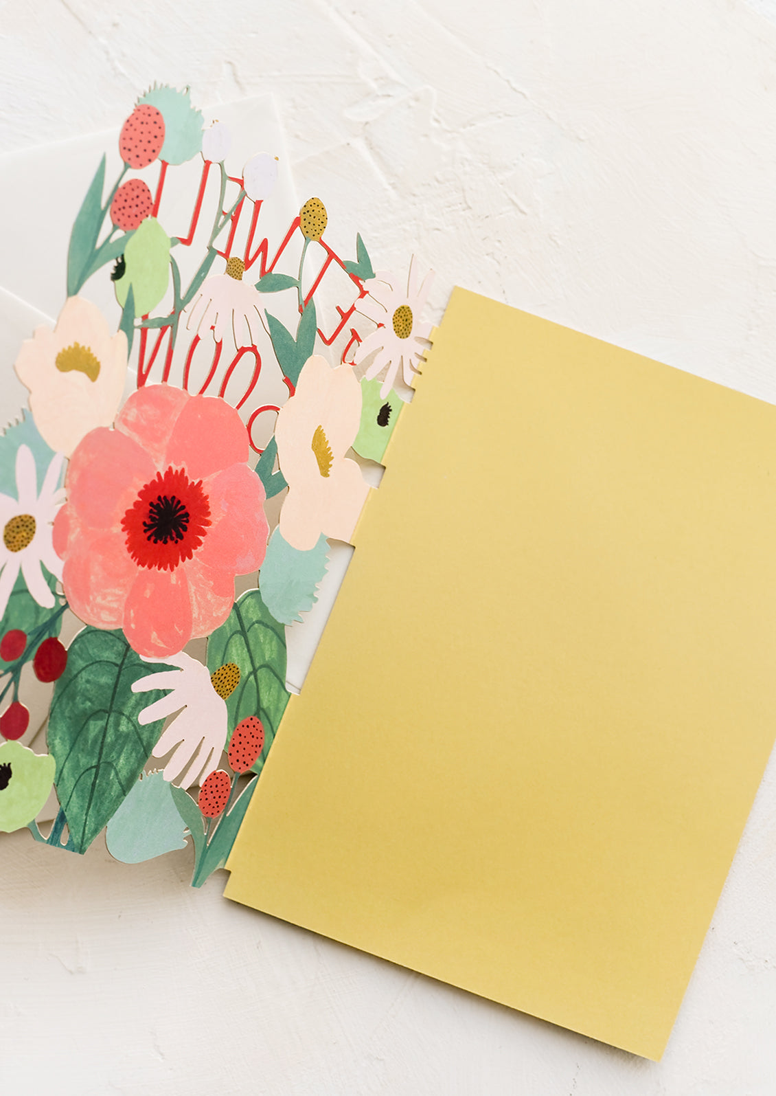 A lasercut floral greeting card reading 'get well soon'.