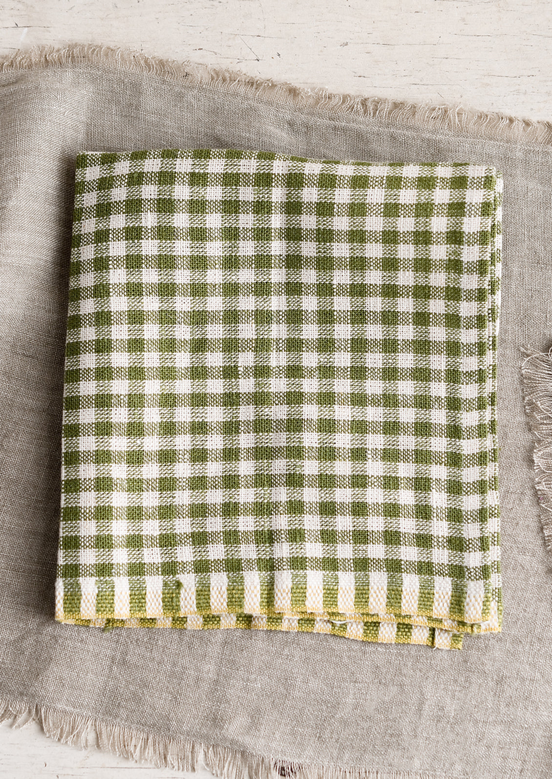 A linen dinner napkin in olive gingham.
