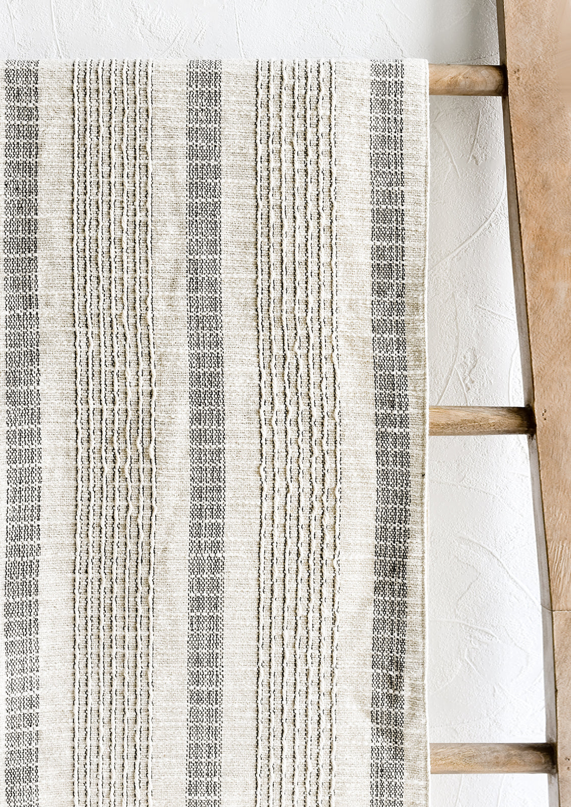 A cream and black striped table runner.