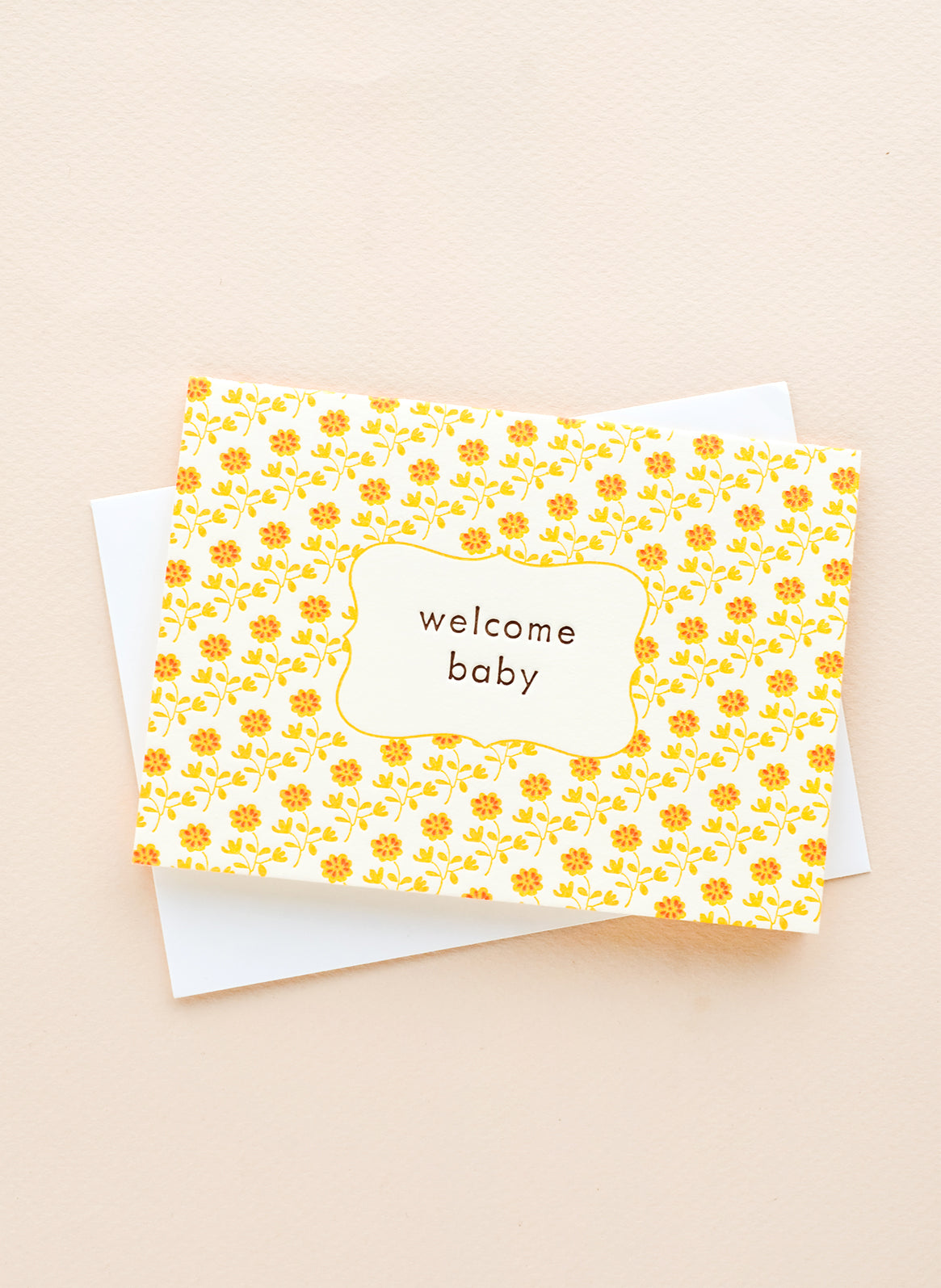 Greeting card with yellow and orange floral print and "Welcome baby" text at center