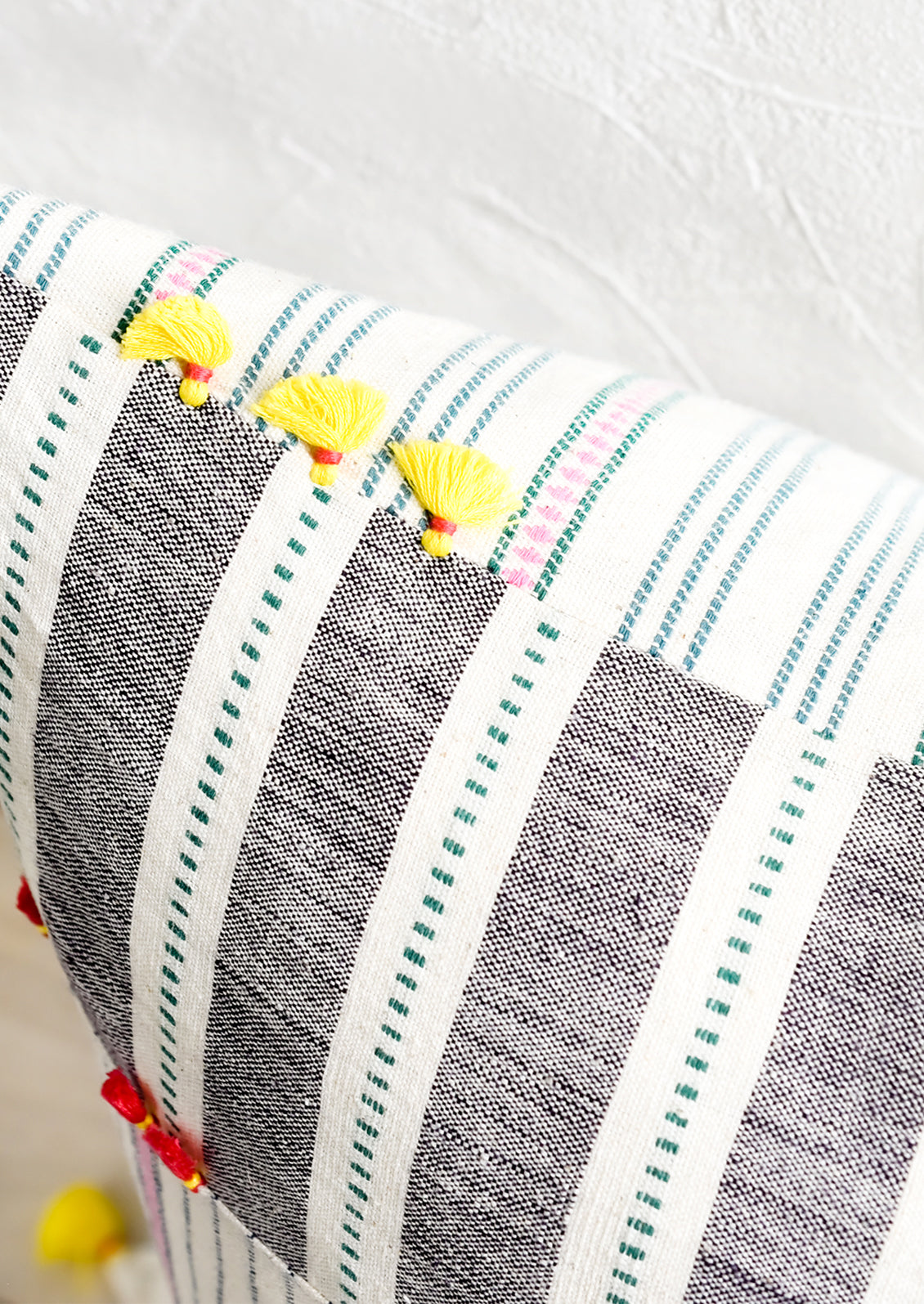 Two sided pillow detailing with tassels.