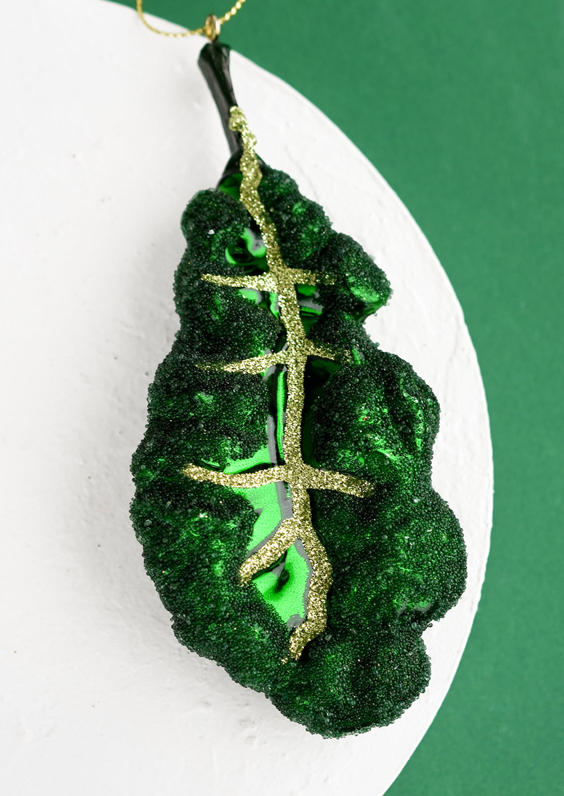 A holiday ornament of a leafy kale piece.