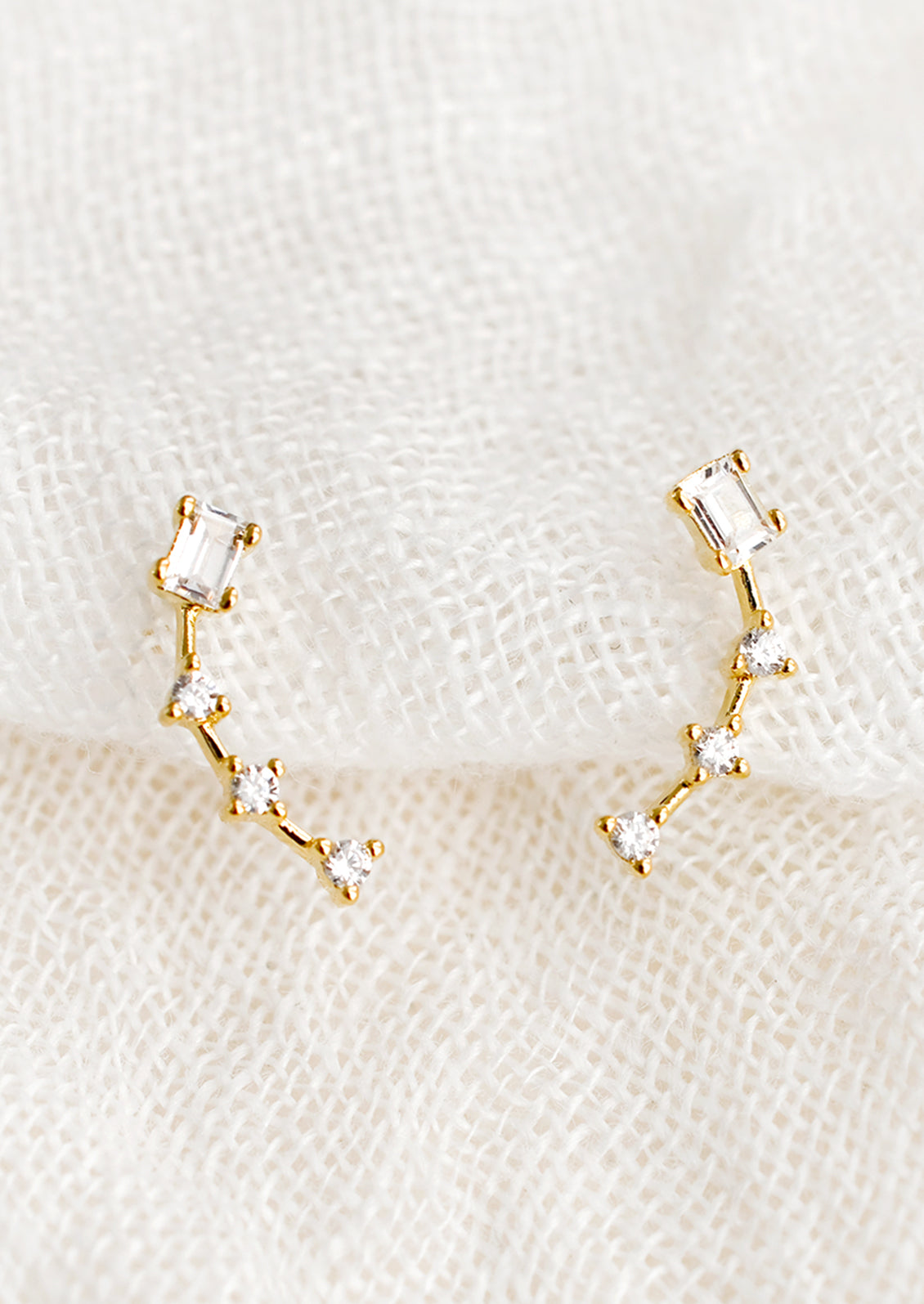 A pair of constellation-like gold studs with clear crystal.