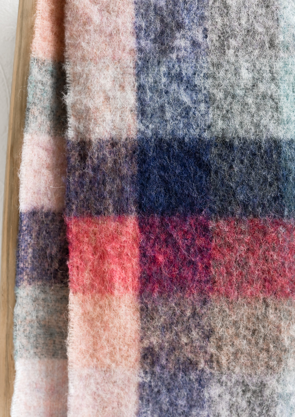 A fuzzy woven wool scarf in pastel madras pattern.