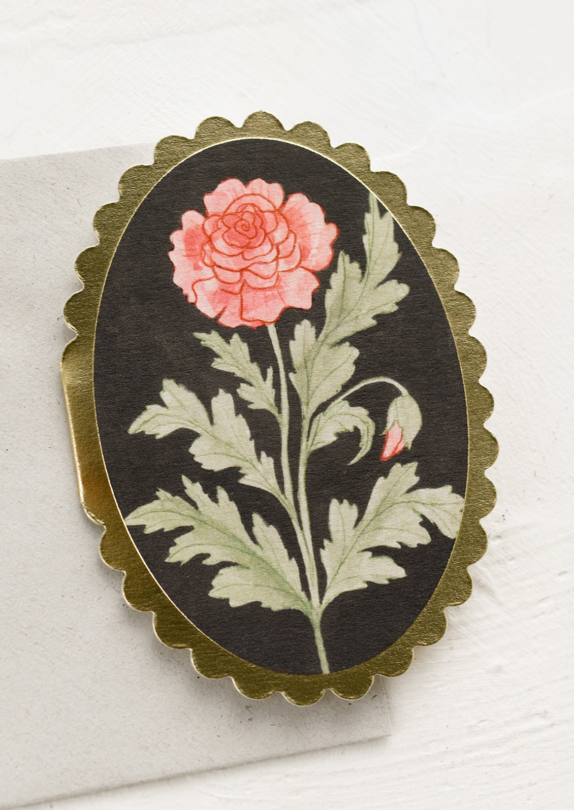 A small oval shaped card with scalloped edges and rose drawing.