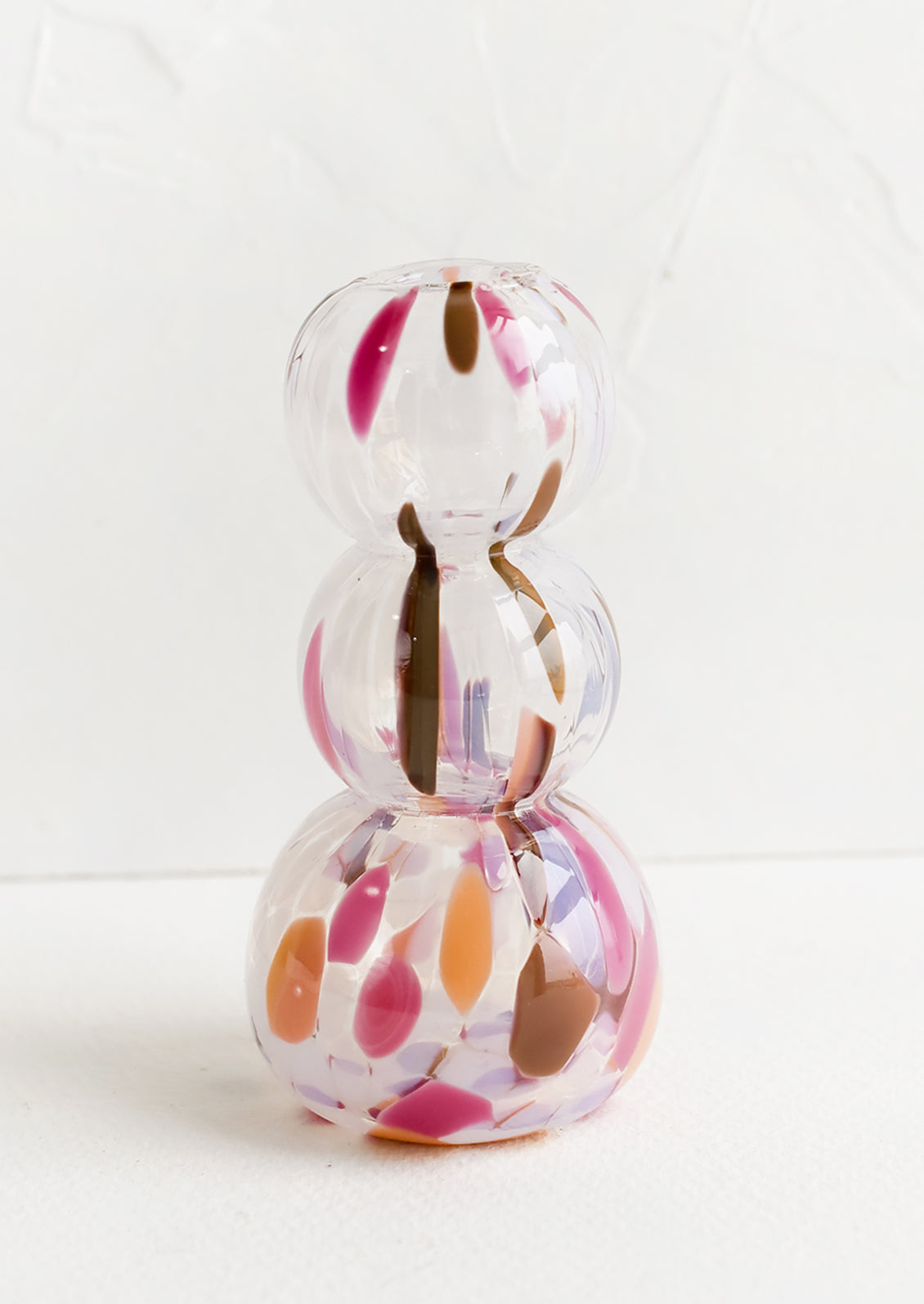 A glass bud vase in stacked bubble shape with orange, brown and pink speckles.