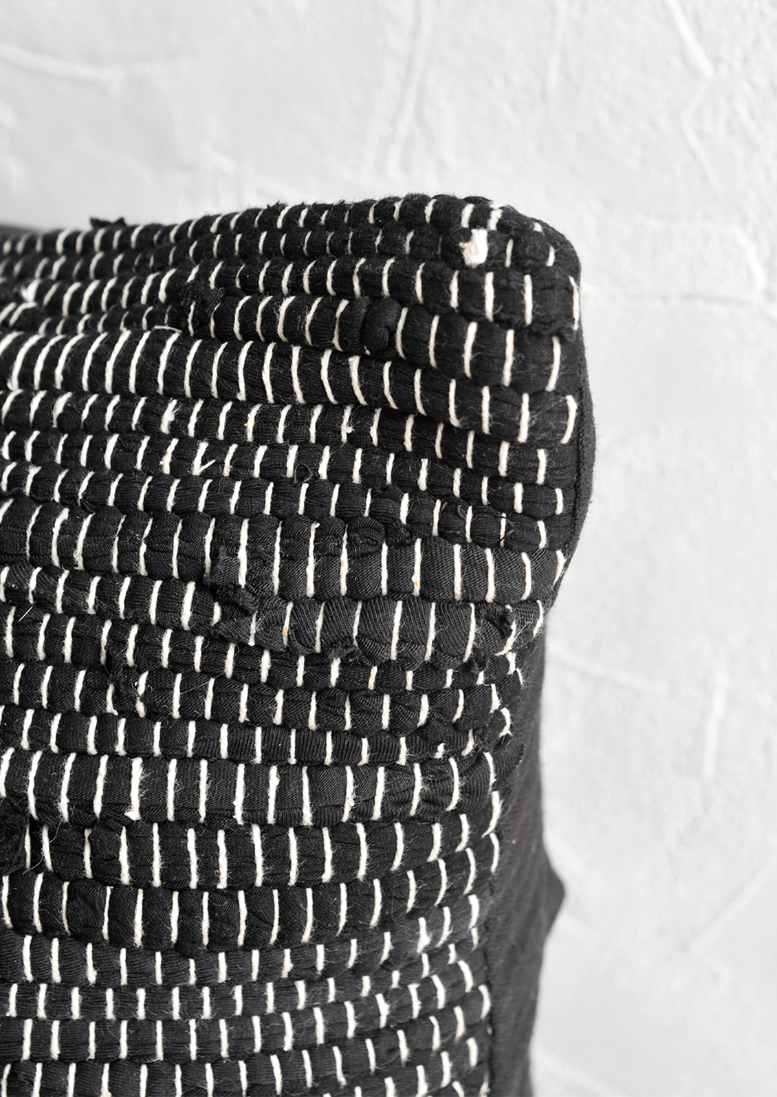 A black and white chindi weave throw pillow.