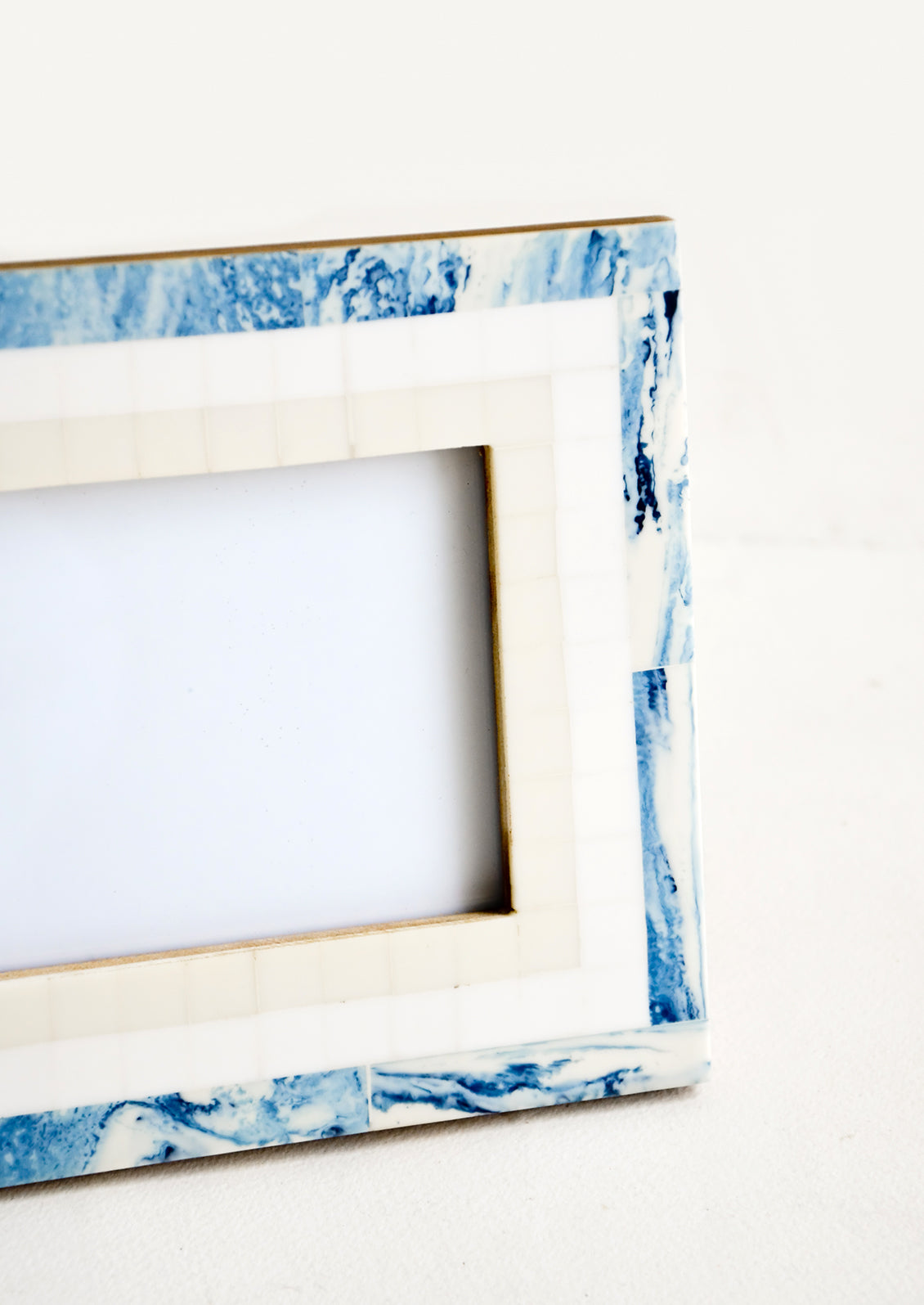 A tiled border in blue, white and cream around a decorative photo frame.