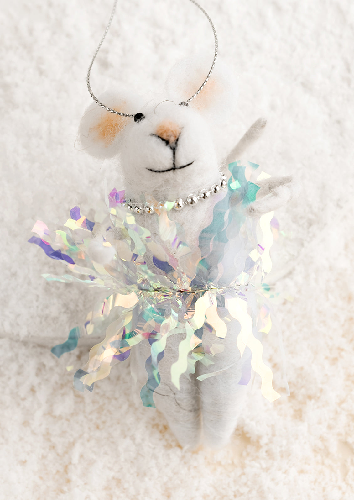 A felted holiday ornament of a mouse wearing a glittery tutu.