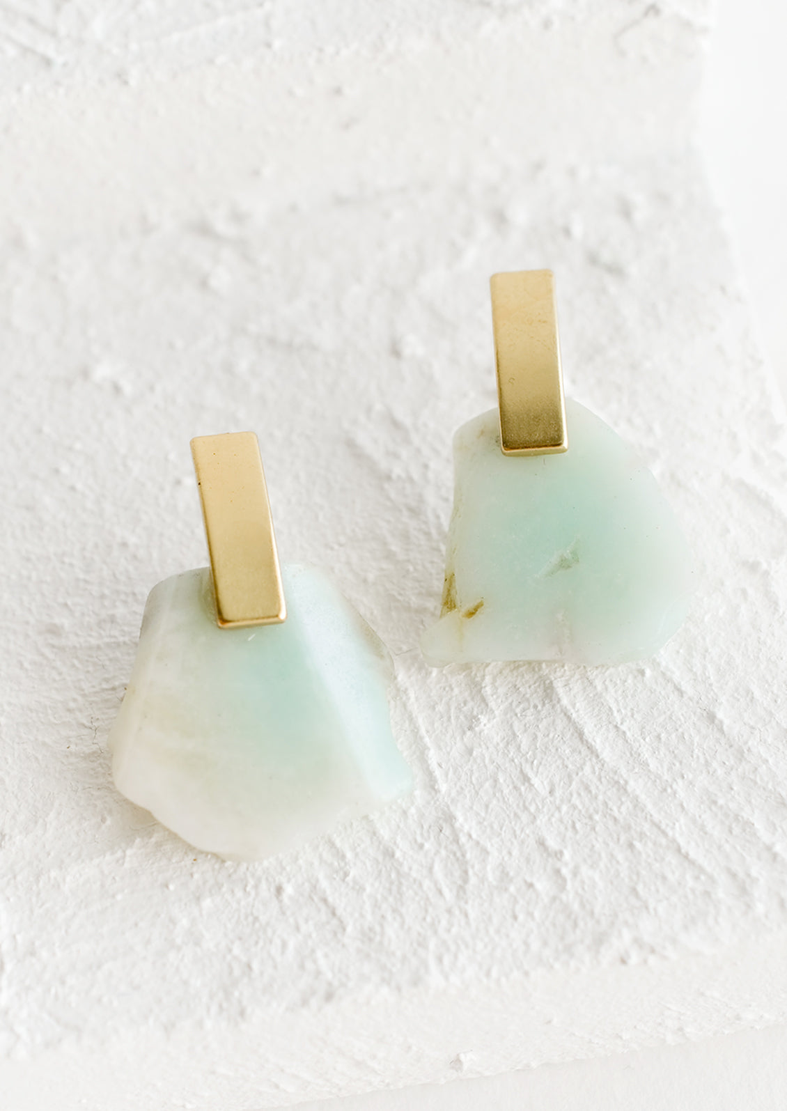 Pair of earrings with raw amazonite gemstone slice and rectangular brass posts.