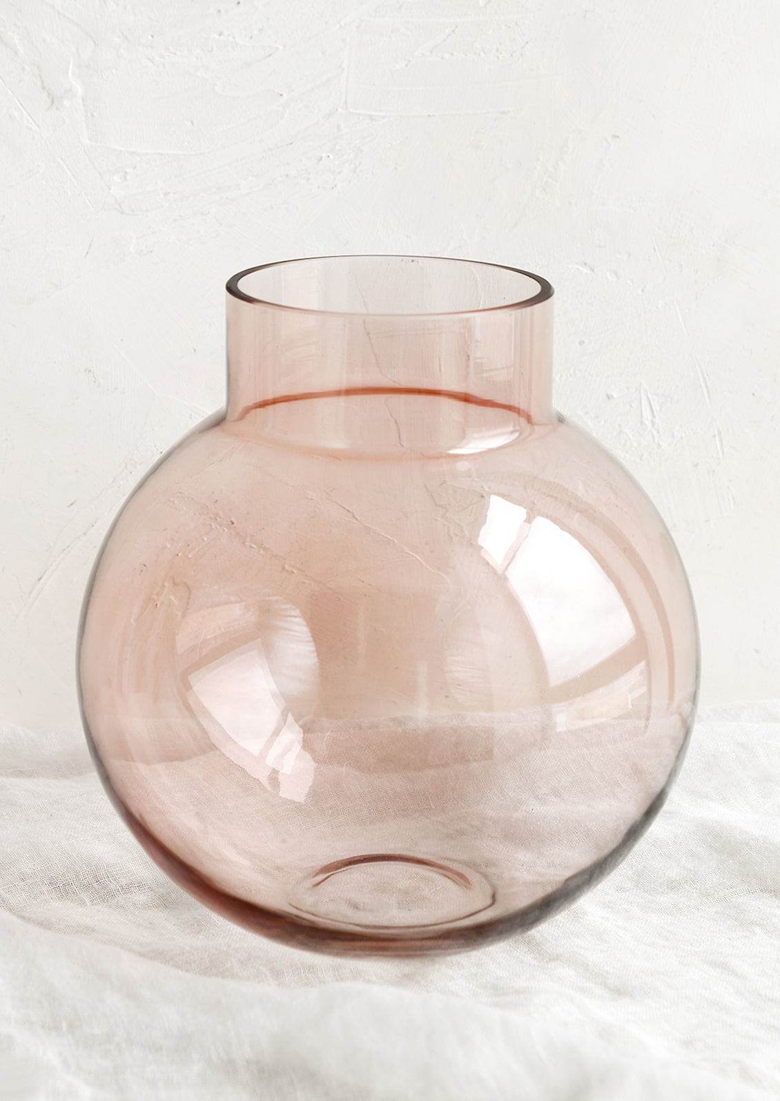 A round shaped glass vase in transparent pink.