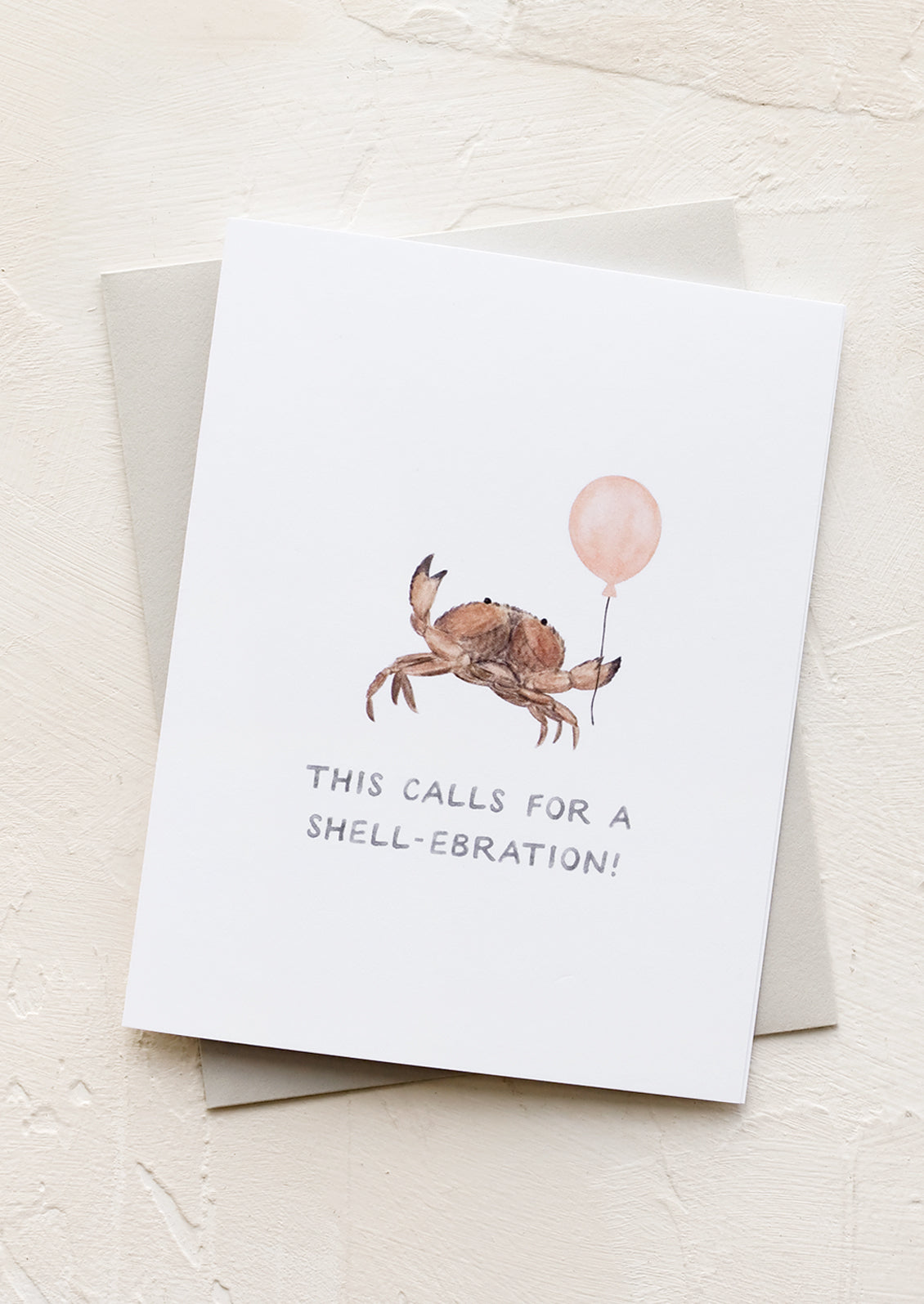 A greeting card with crab holding balloon.