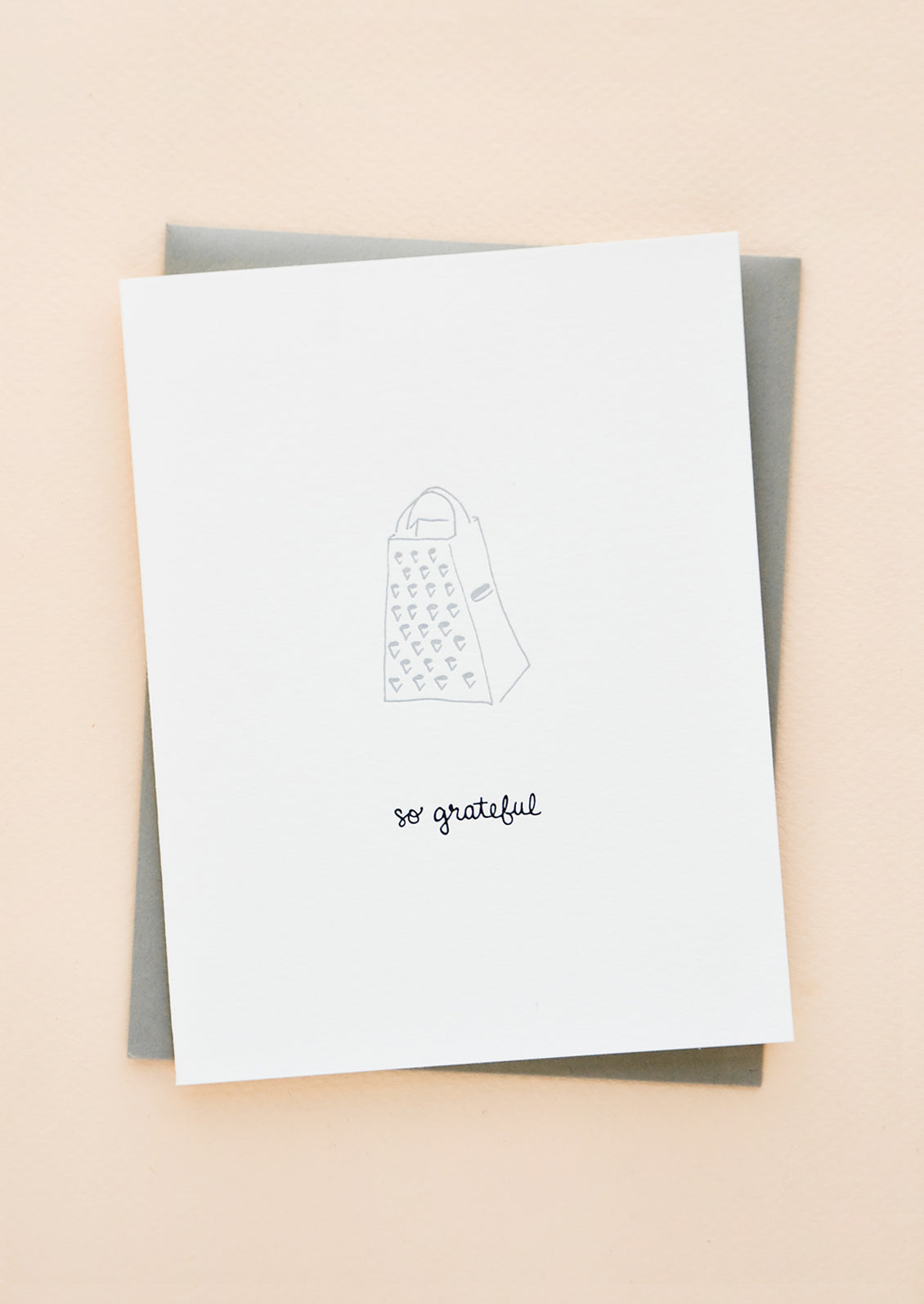 Greeting card with letterpress printed grater and black cursive text reading "So grateful". With grey envelope.