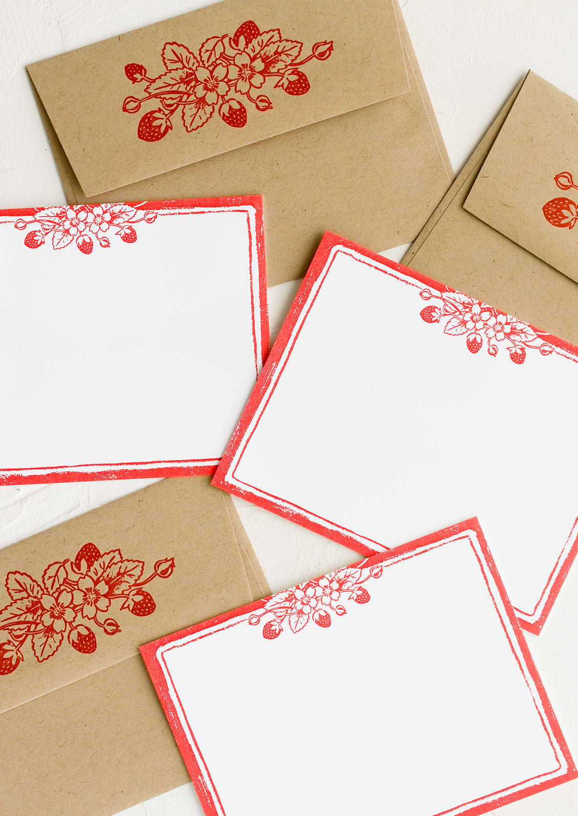 A set of white flat notecards with strawberry print border.