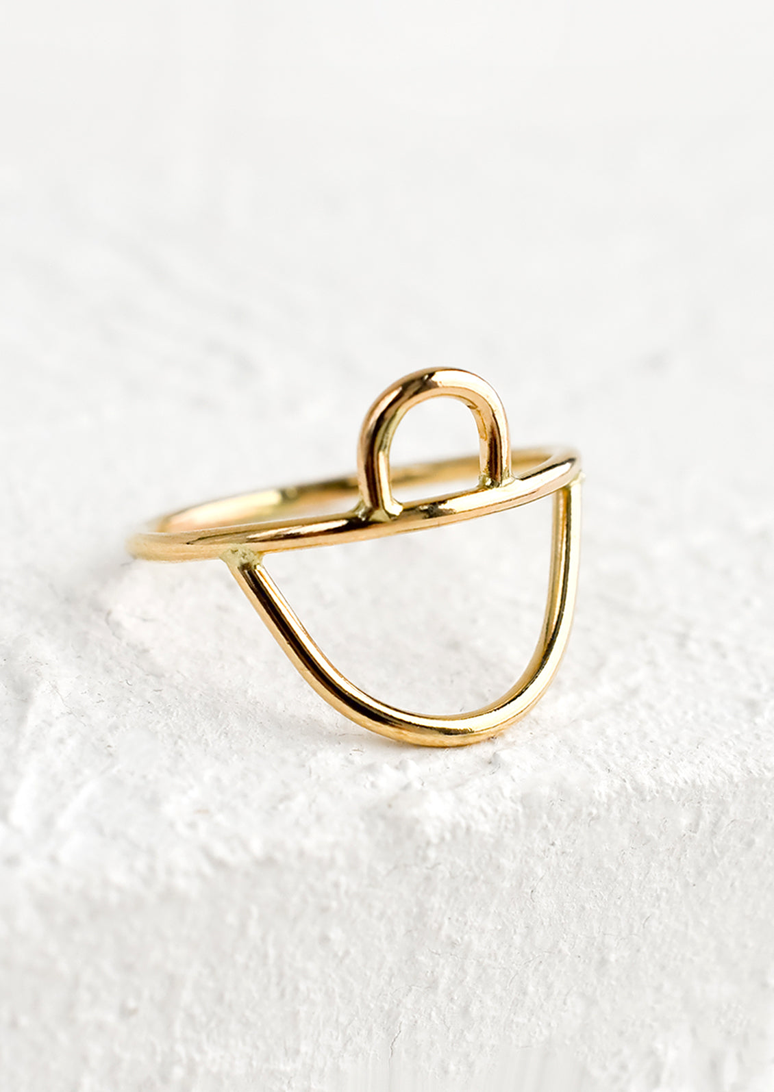 A gold ring with small arc on top and wide arc on bottom.