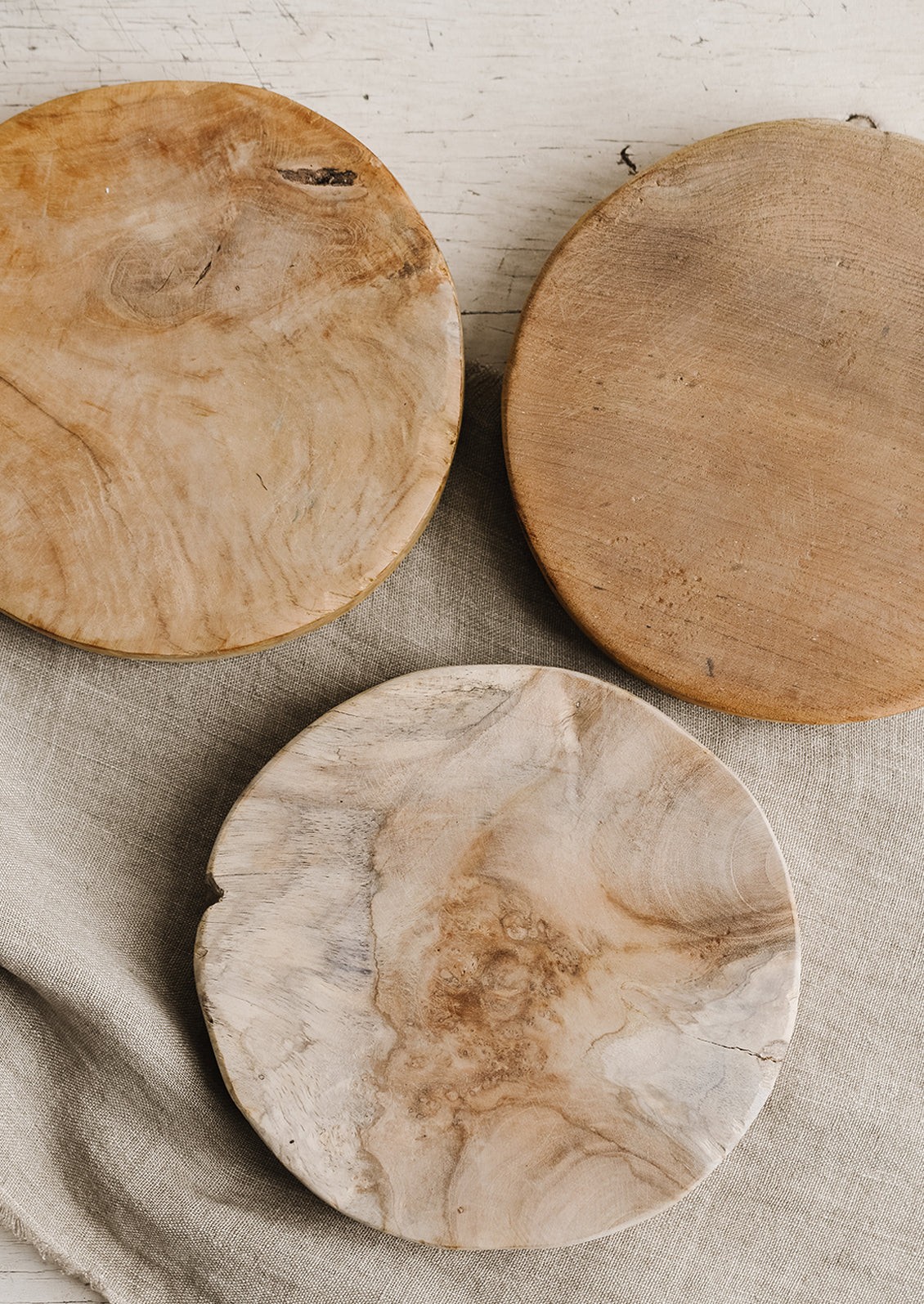 A round pedestal board made from natural teak.