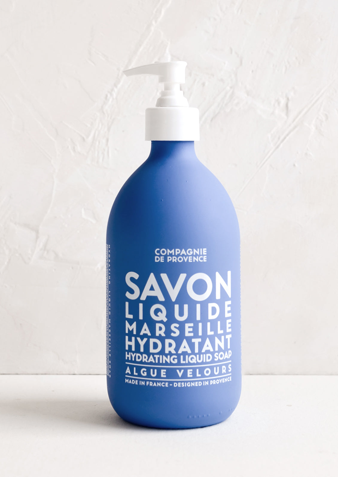 A bottle of soap in frosted blue glass.