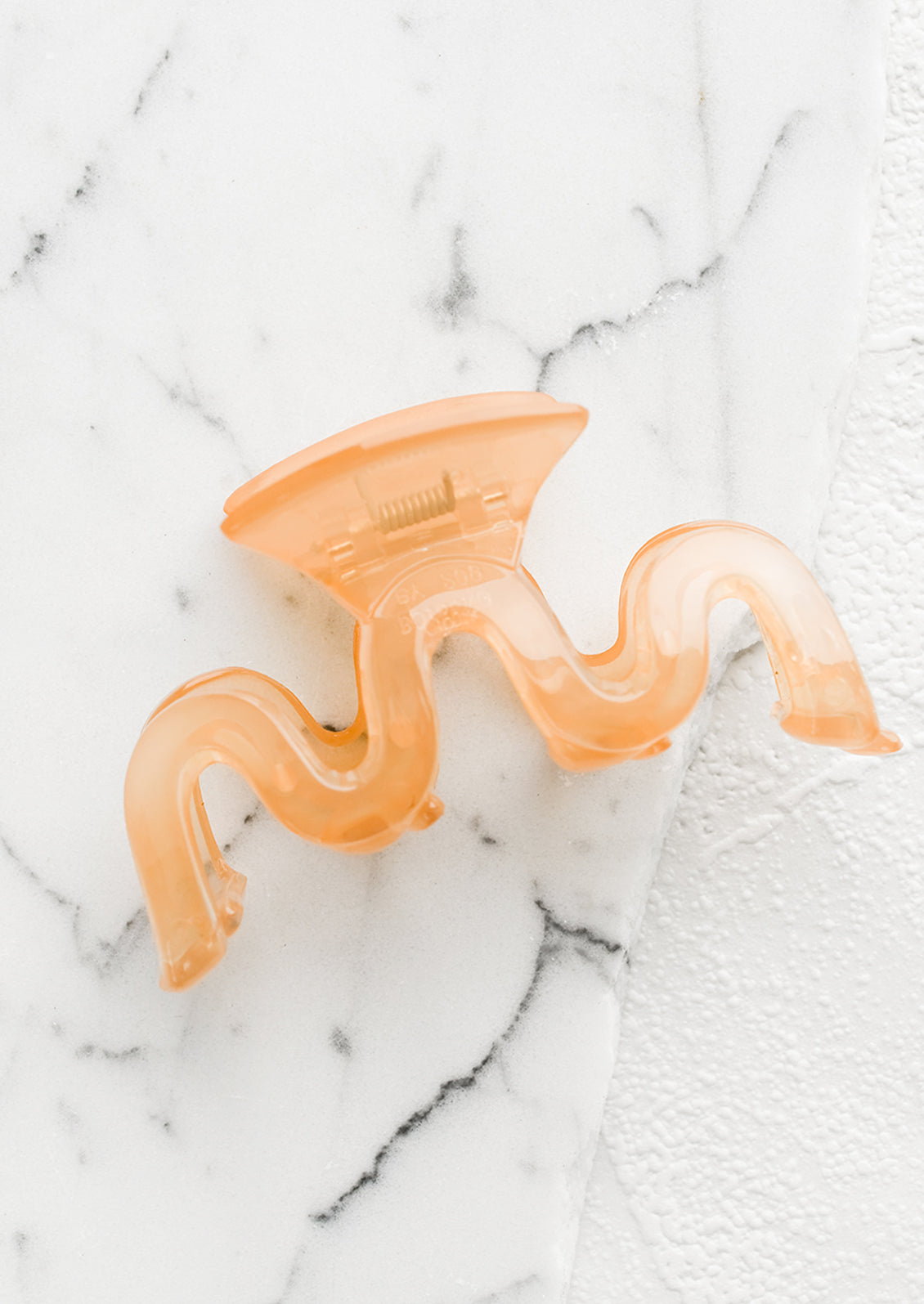 A wavy squiggle hair claw in peach.