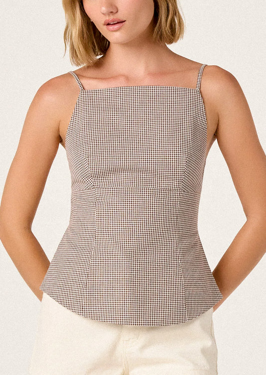 Woman wearing a checkered top with a plain background