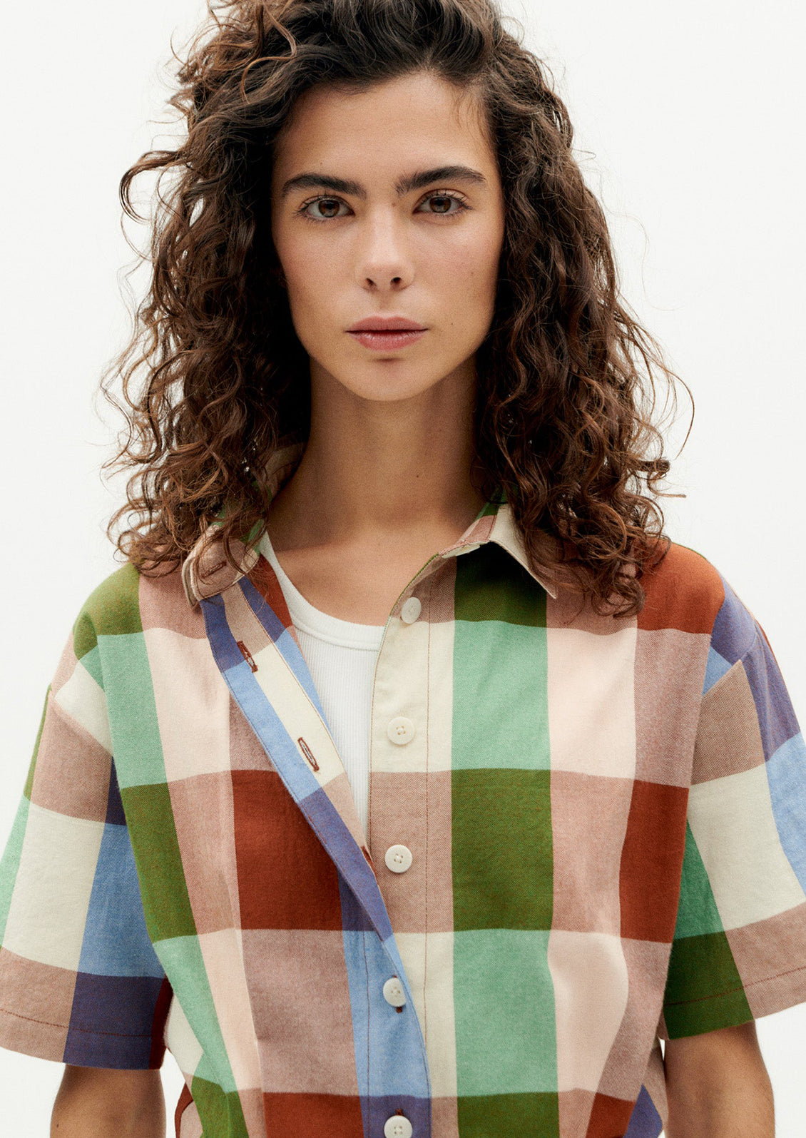 A woman wearing a romper in colorful madras cotton.