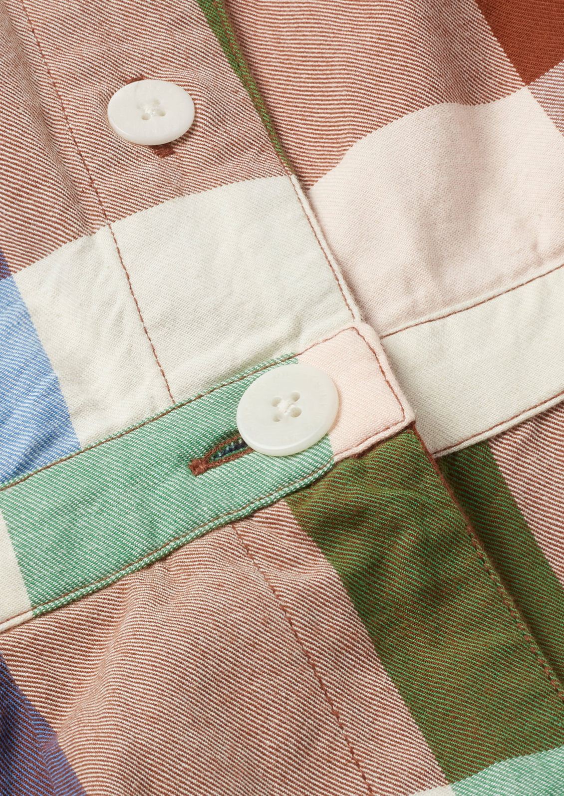 Colorful madras cotton fabric with white buttons.