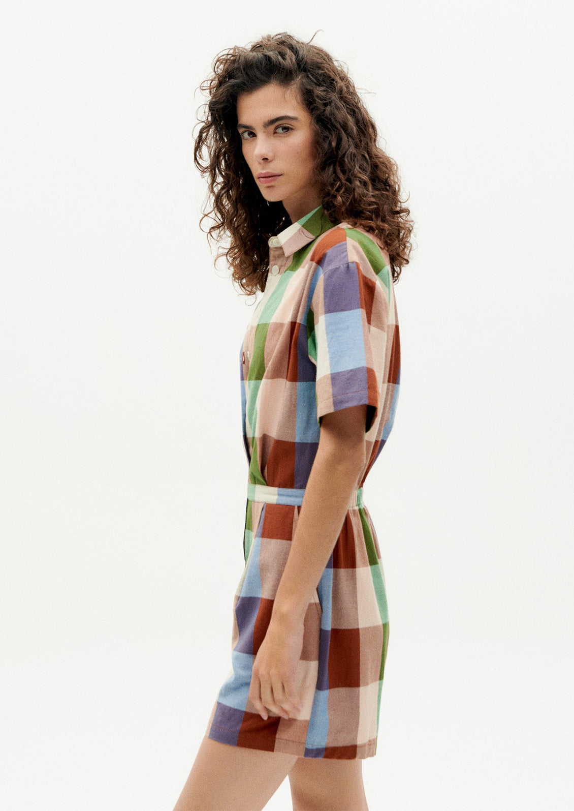A woman wearing a romper in colorful madras cotton.