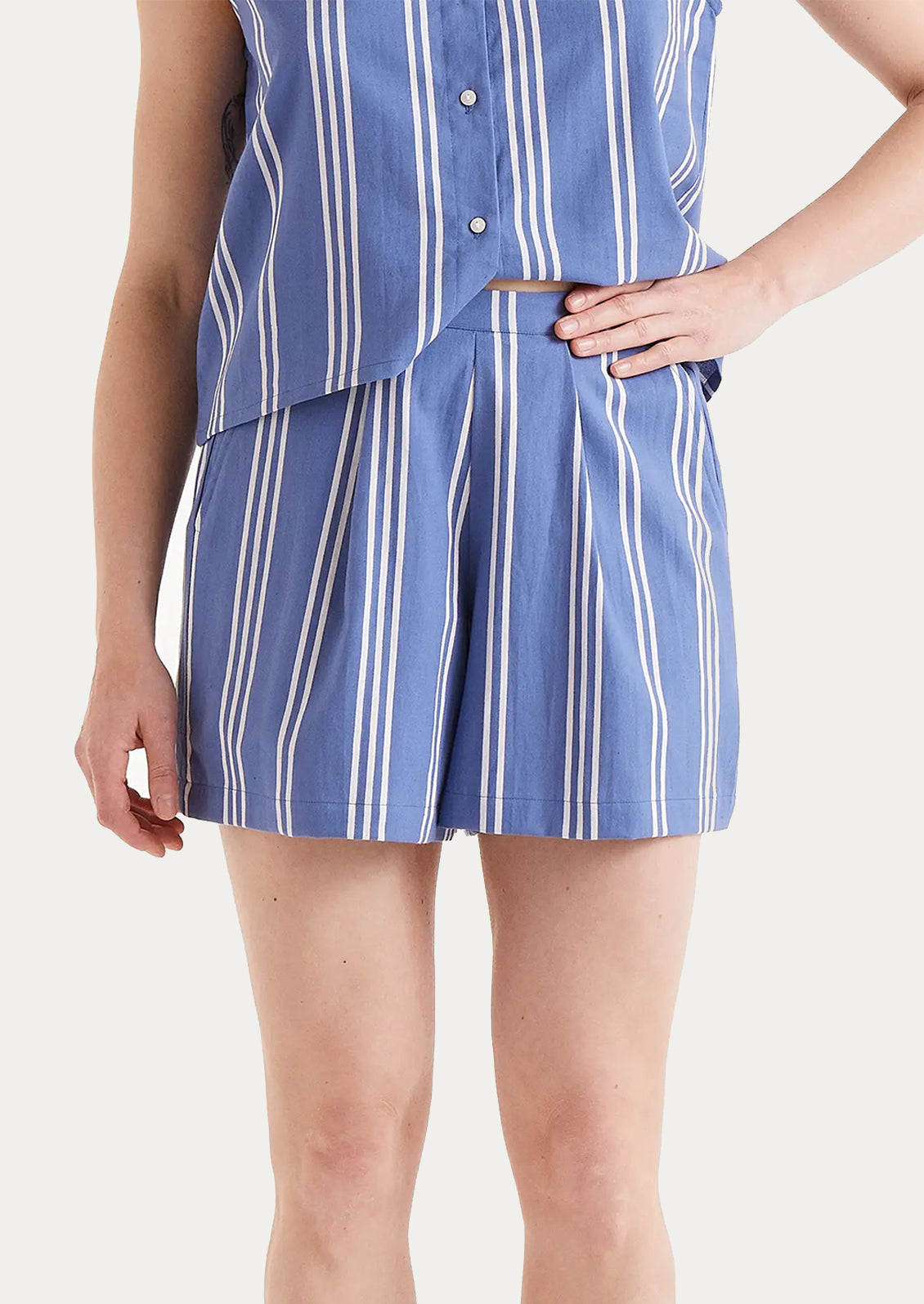 A woman wearing a pair of striped shorts in blue and white.