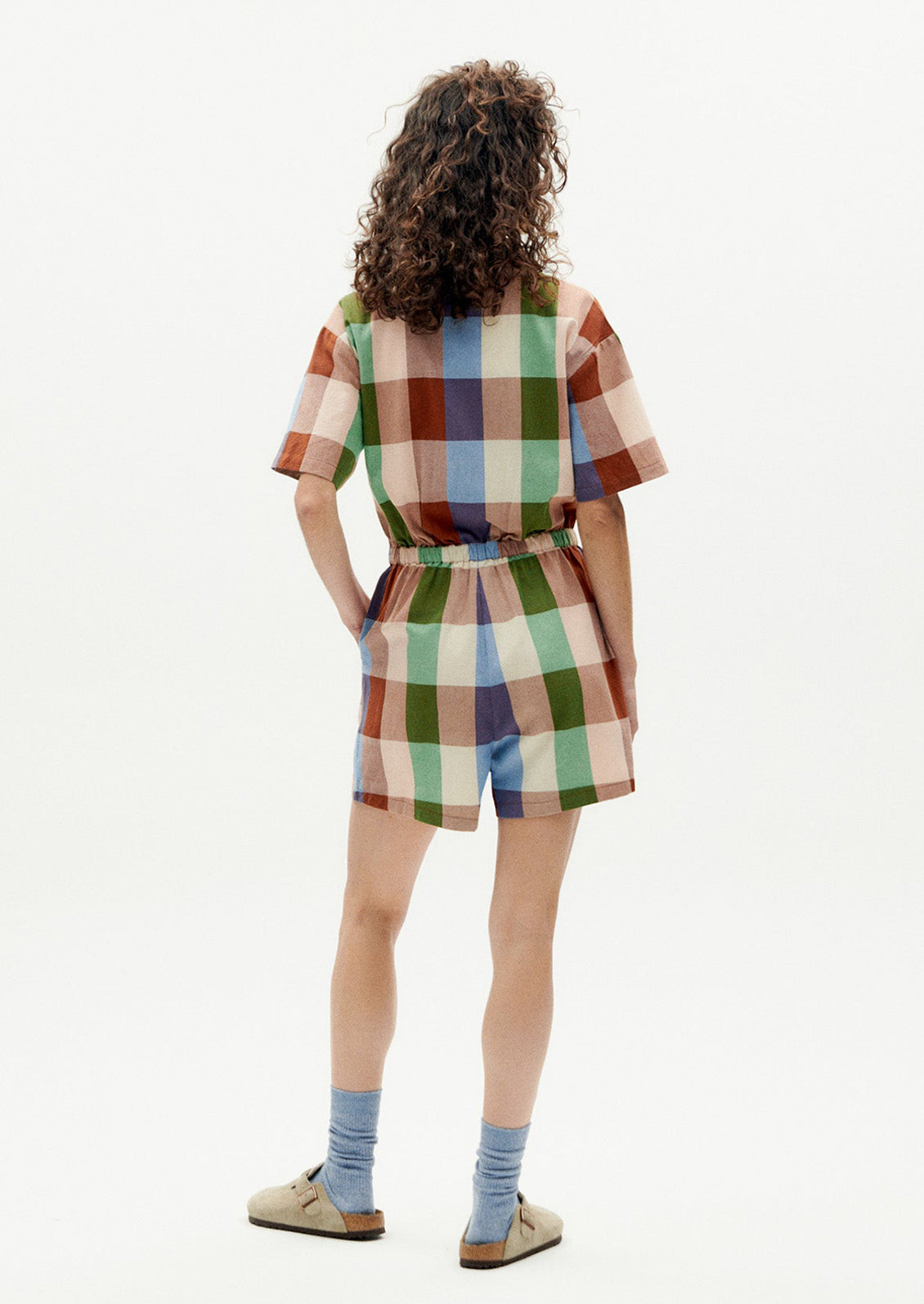 A woman wearing a romper in colorful madras cotton.