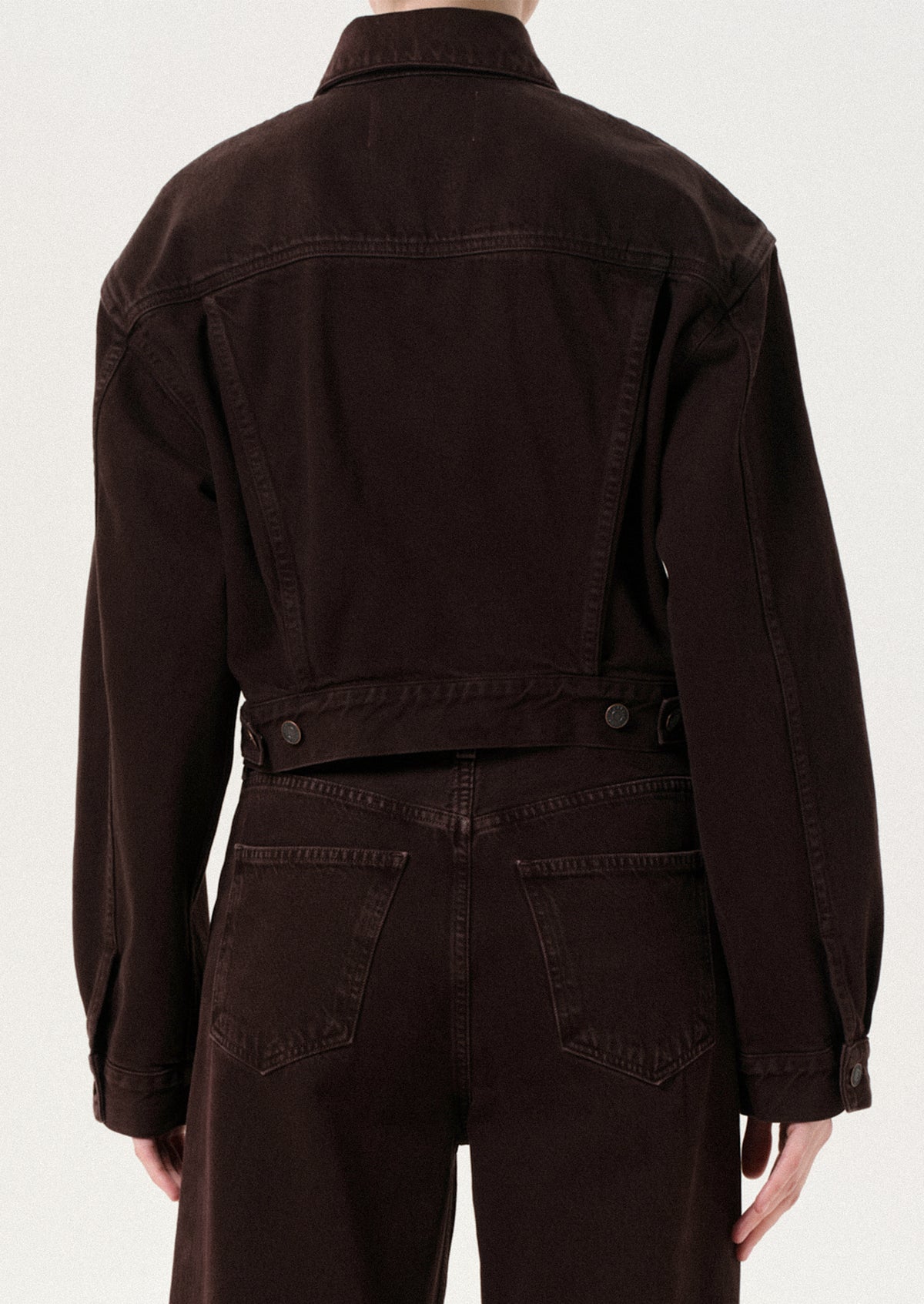 Brown jacket and pants worn by a person on a white background