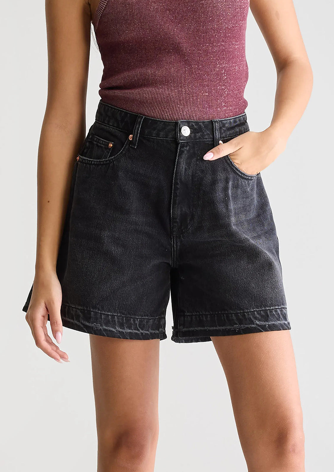 A person wearing a pair of wide leg denim shorts in charcoal wash.