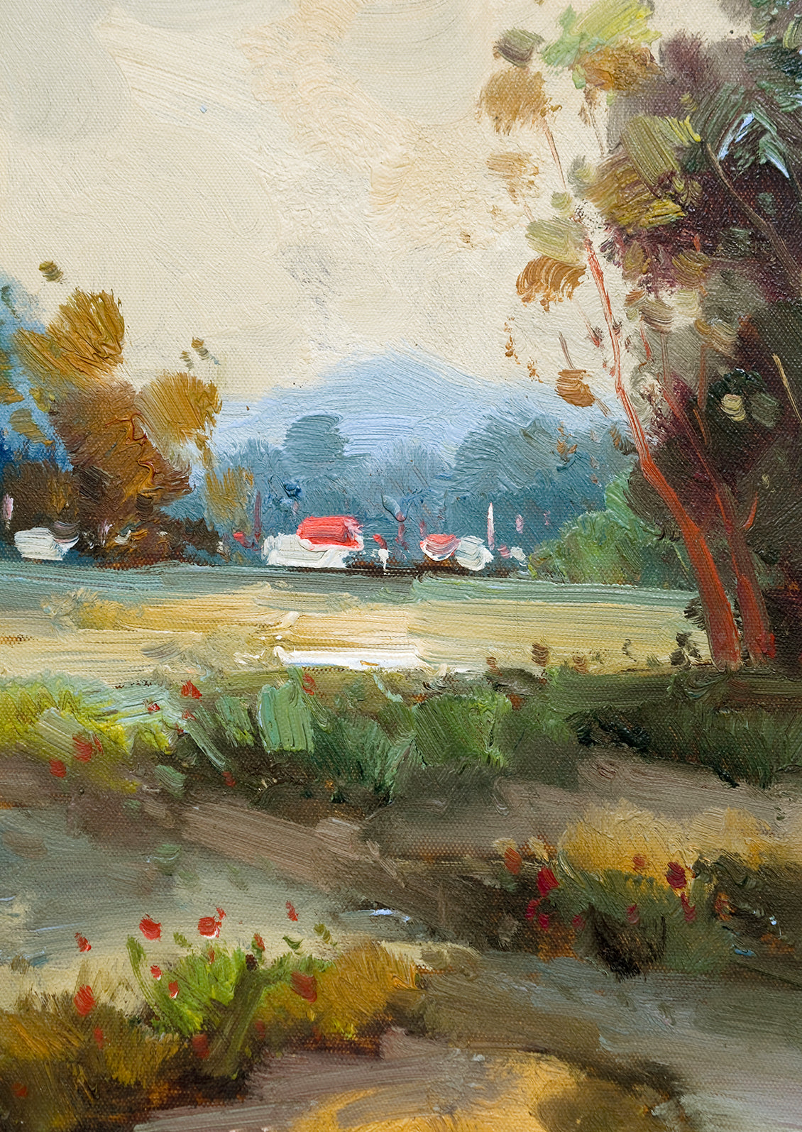 A framed landscape oil painting of trees and houses near a creek.