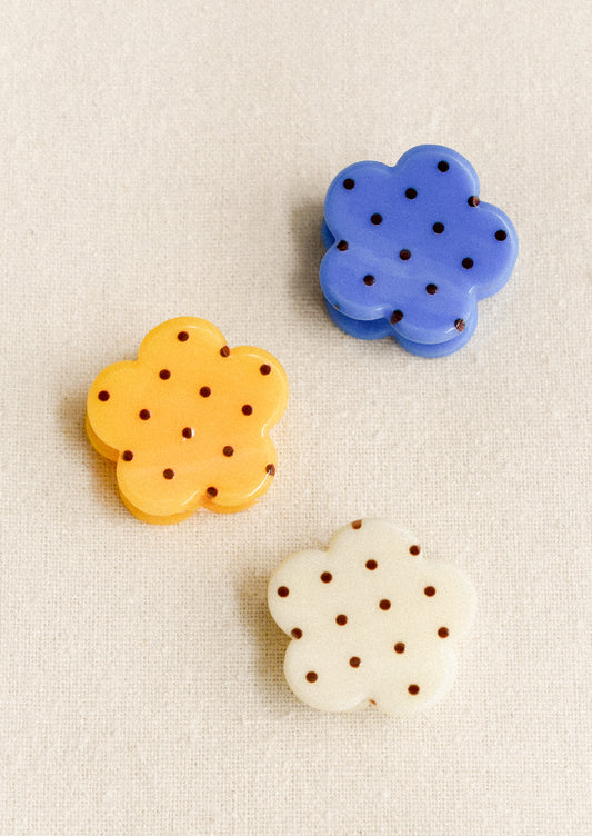 Three mini hair claws with flower shape and polka dot pattern, in assorted colors.
