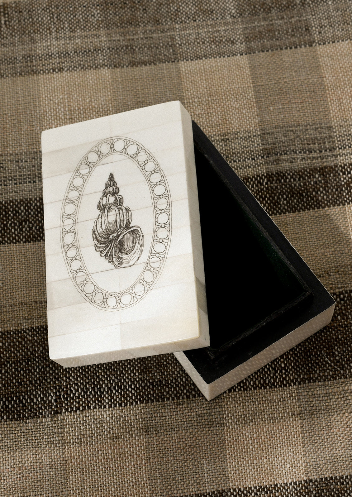 A decorative storage box with shell motif.