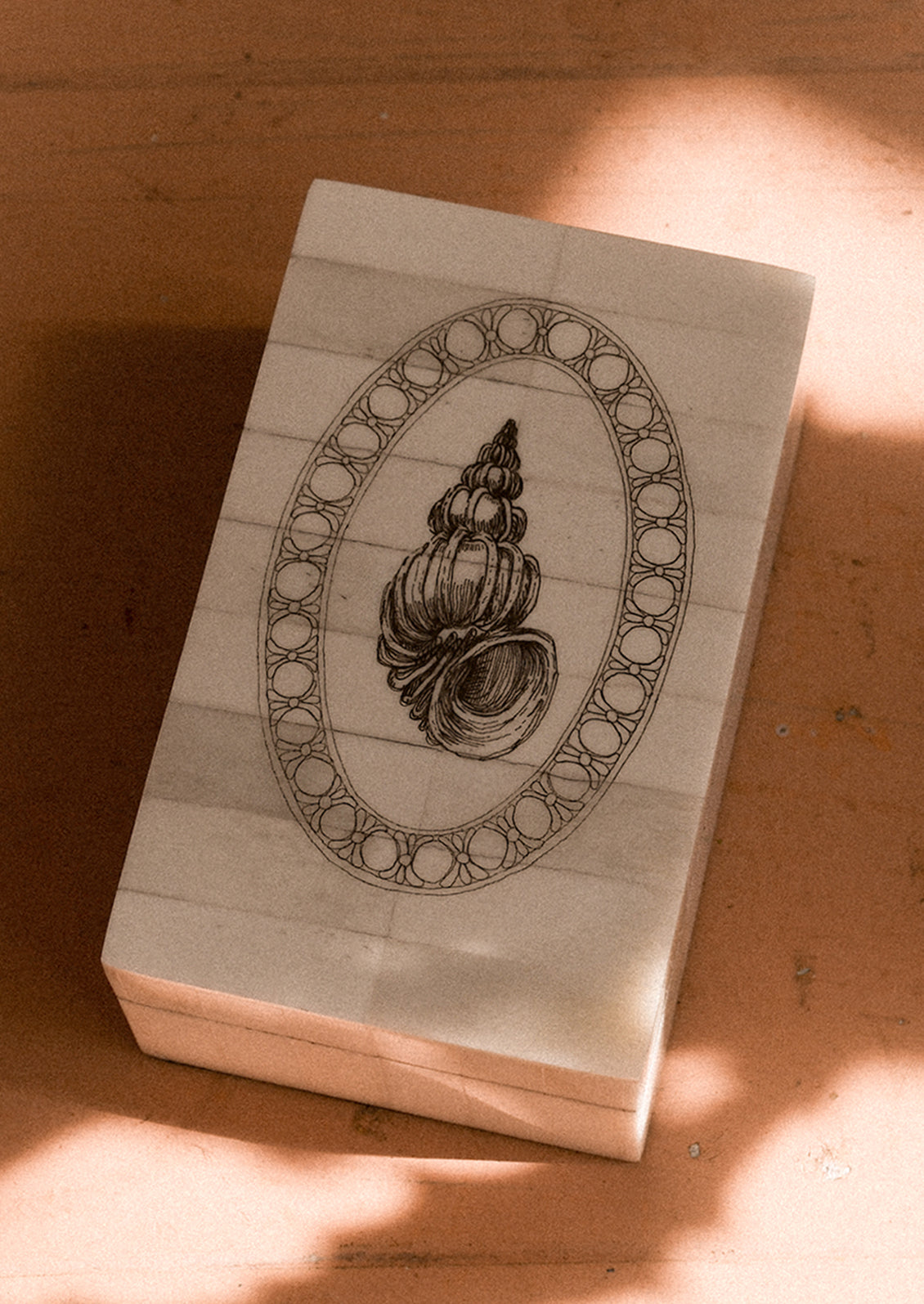 Wooden stamp block with a shell design on a wooden surface