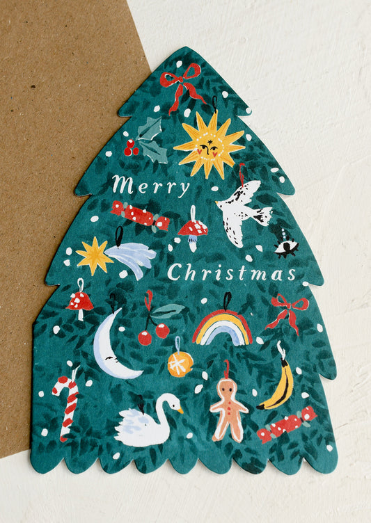 A diecut card in the shape of a Christmas tree adorned with decorations, text reads "Merry Christmas".