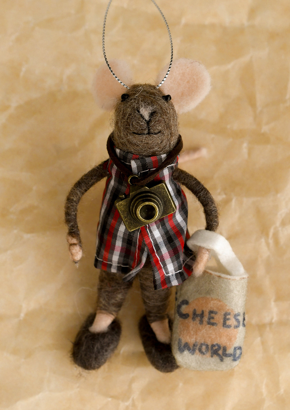 A mice felt ornament dressed as tourist of a cheese factory.