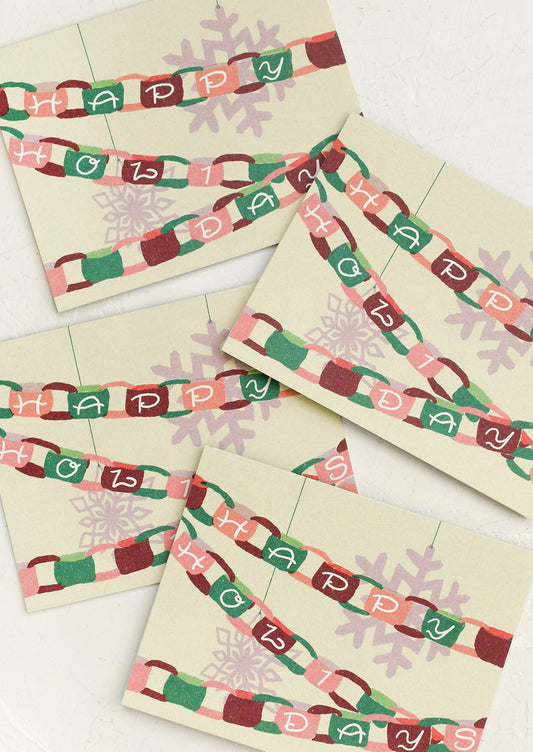 A set of greeting cards with depiction of paper chain garland, text reads "Happy Holidays".