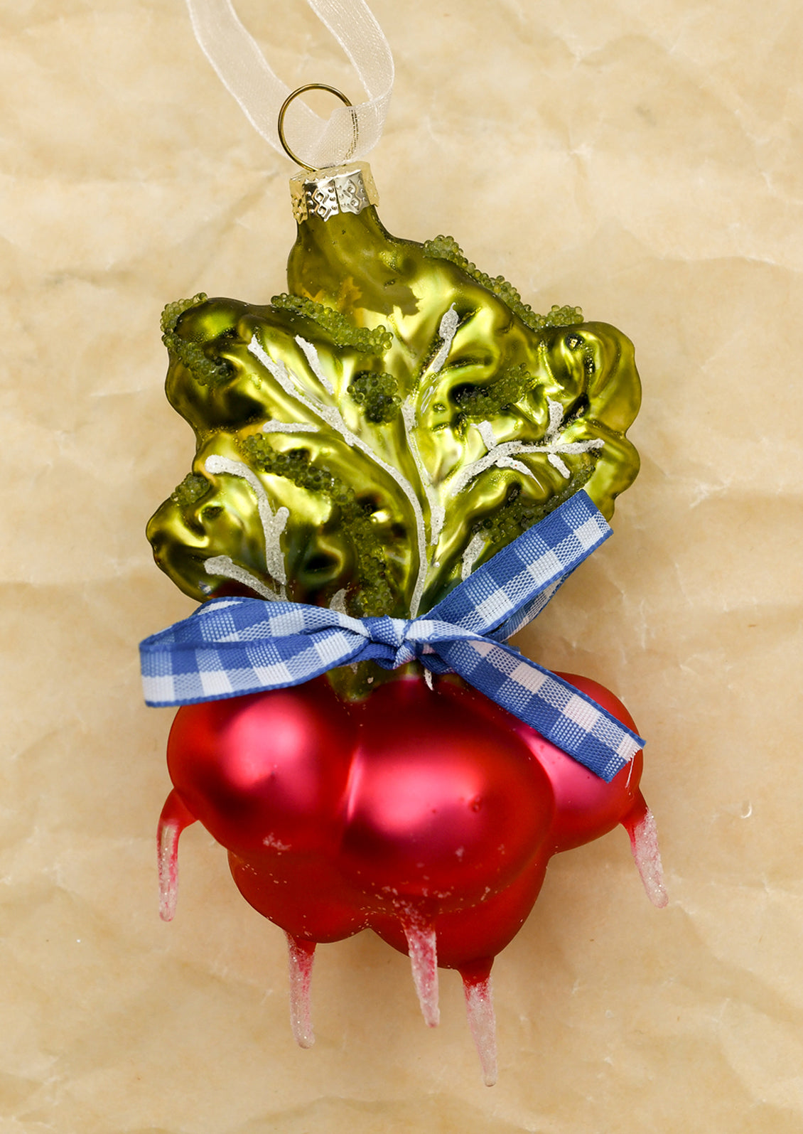 A glass ornament depicting a bundle of radishes tied with blue gingham ribbon.