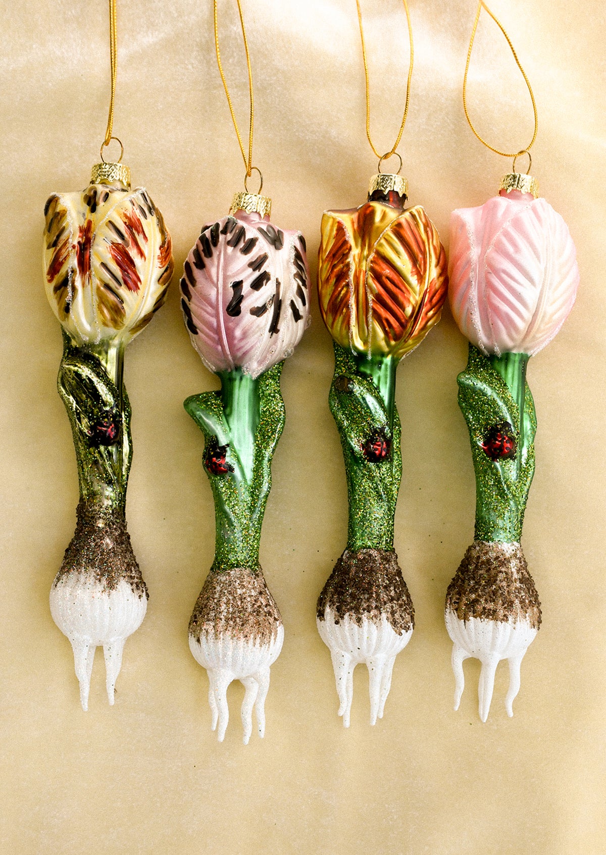 Glass ornaments depicting tulip bulbs with ladybug detail, in four assorted colors.