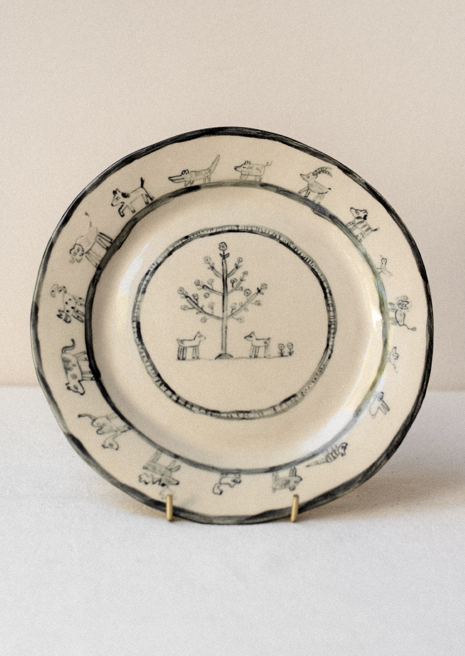 A cream ceramic plate with hand drawn animal print.