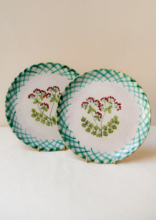 A pair of hand painted Italian plates with parsley flower detail.