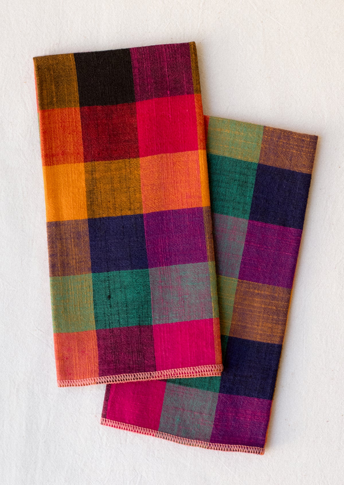 A pair of napkins in colorful gingham check pattern.