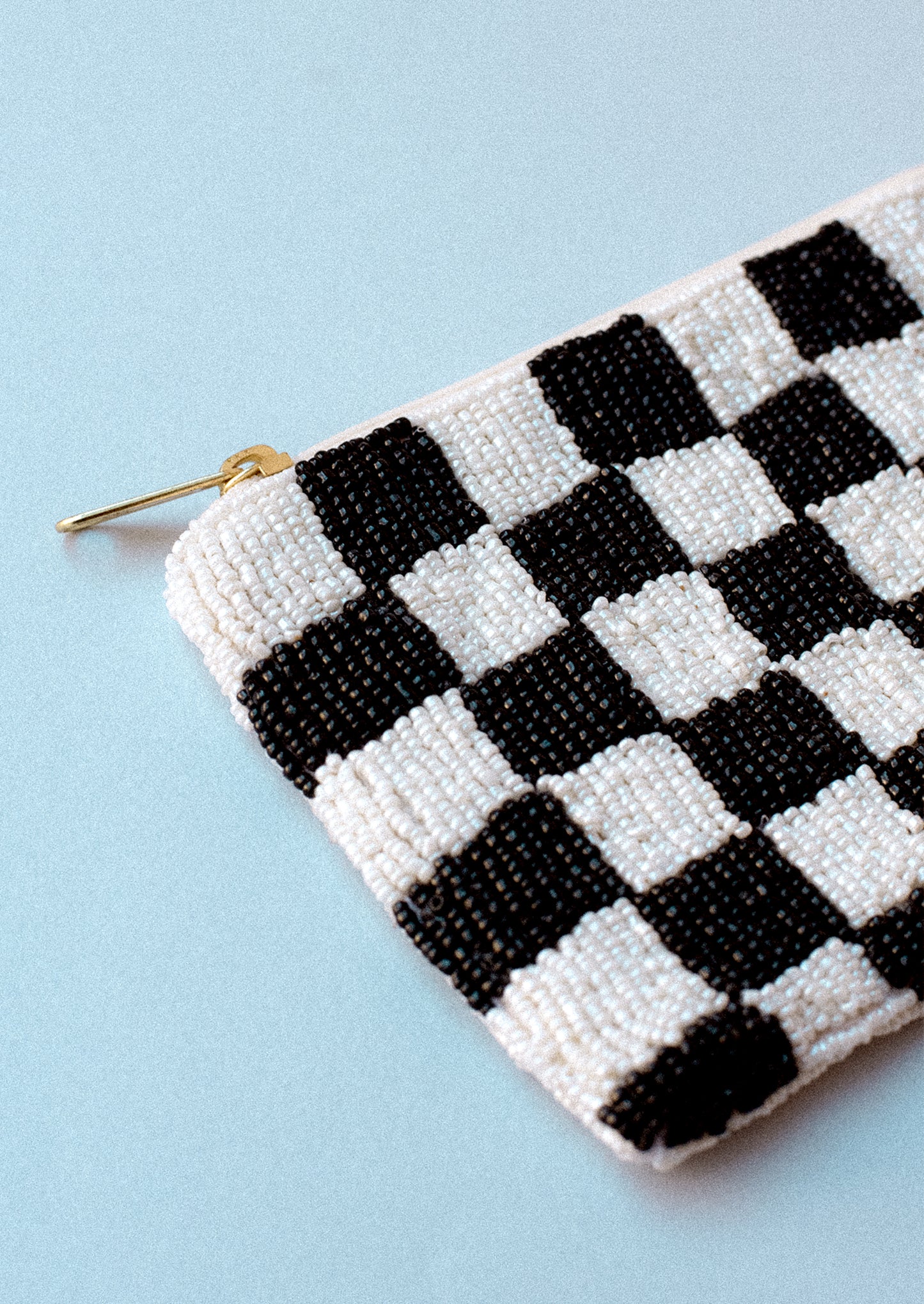 A rectangular coin pouch in black and white checker print.
