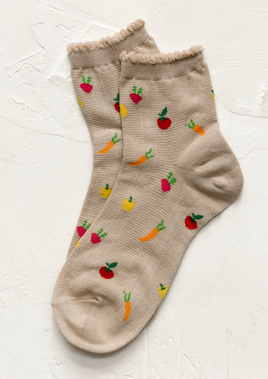 A pair of beige socks with all over vegetable motif.