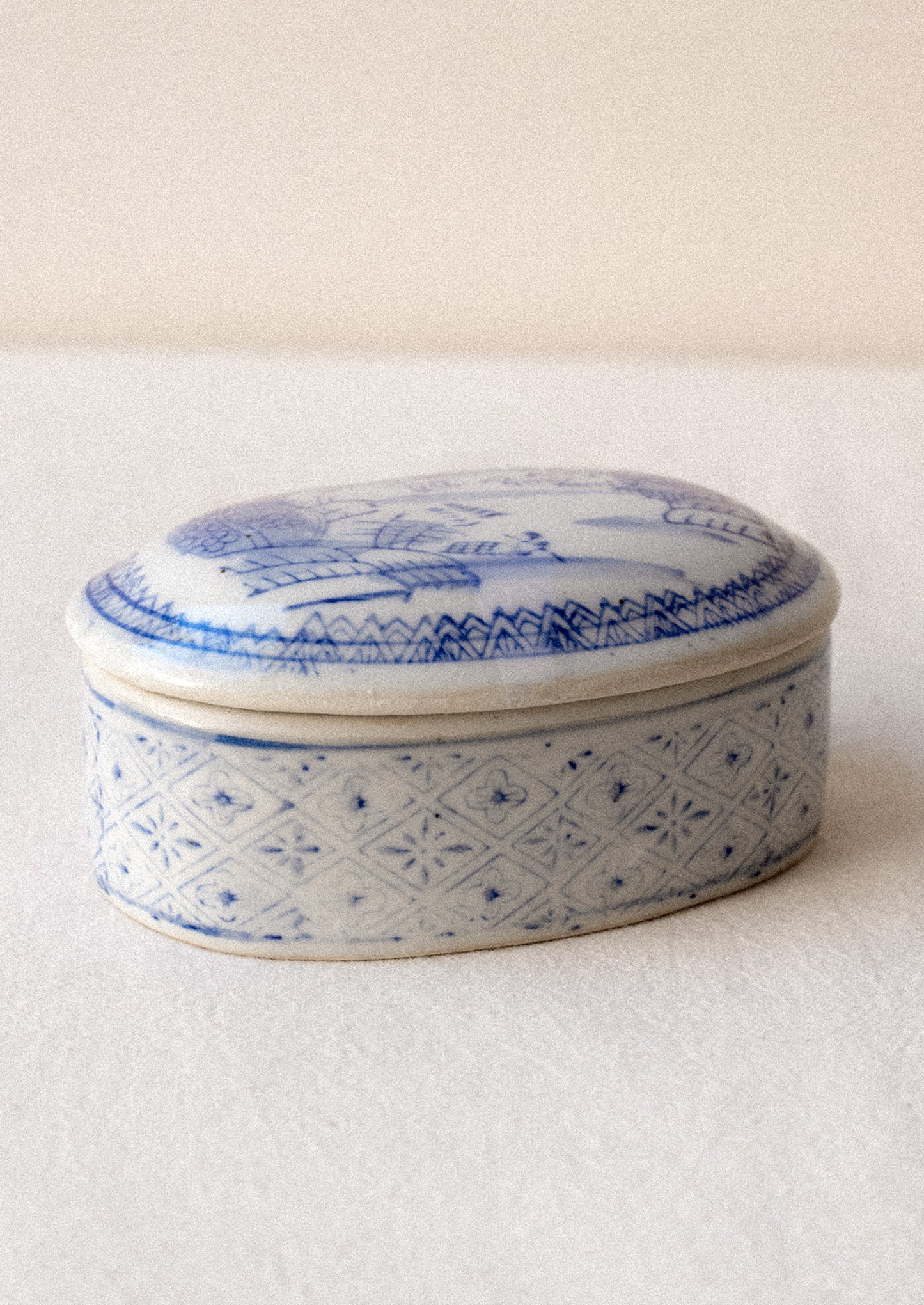 A blue and white chinoiserie patterned lidded ceramic box.