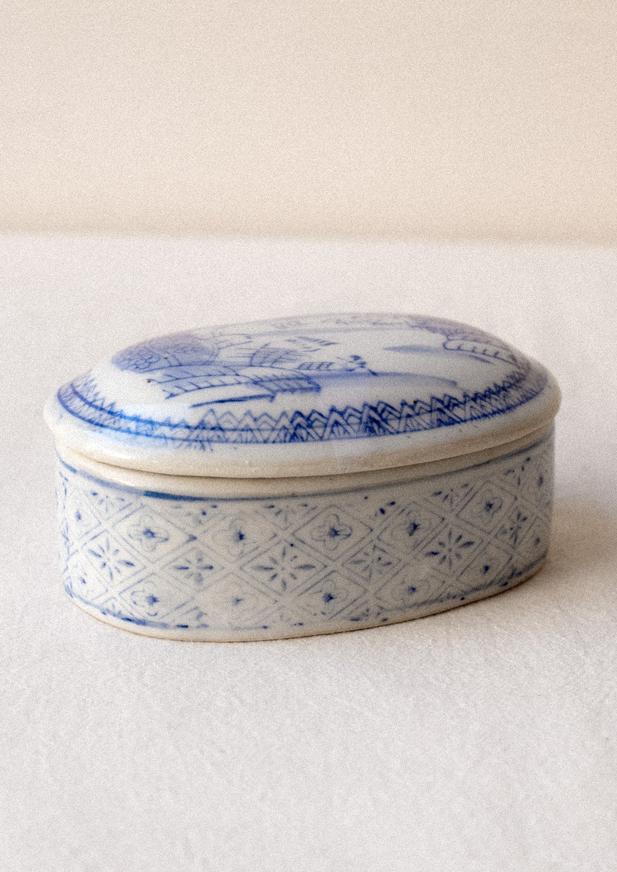 A blue and white chinoiserie patterned lidded ceramic box.