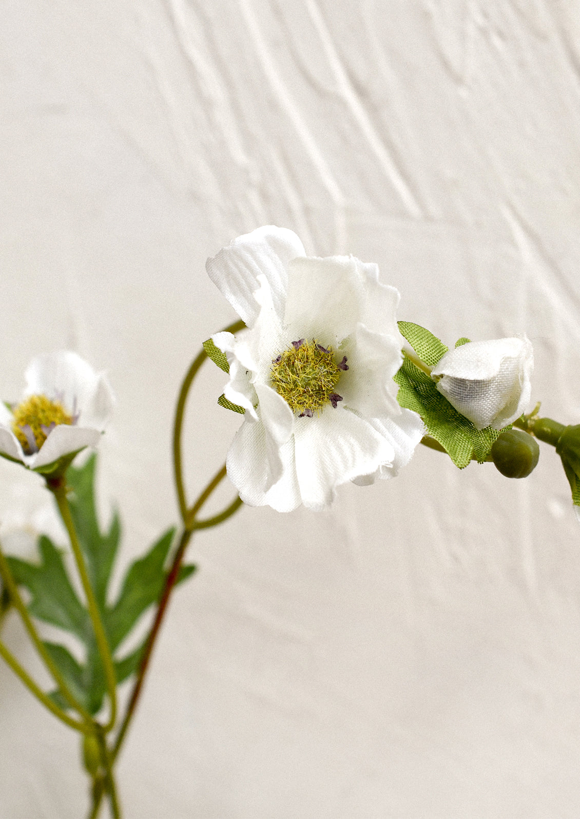 A faux floral spray depicting white wood anemone.